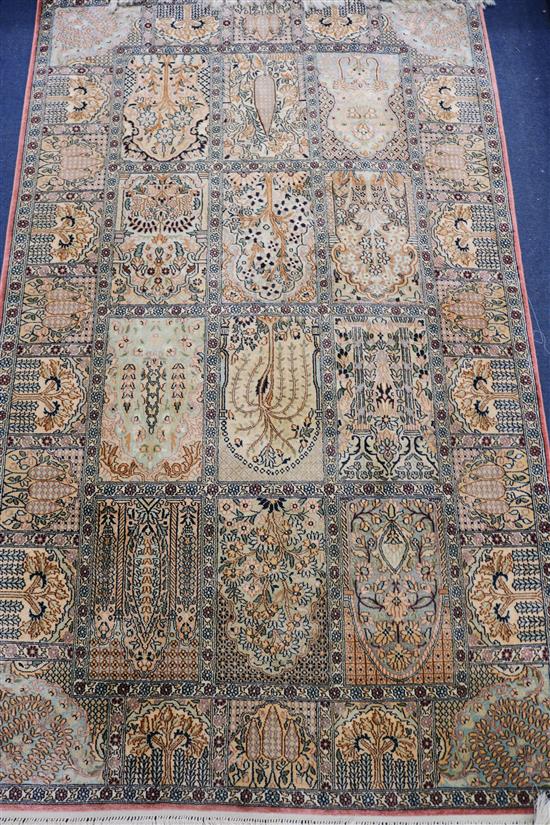 A Persian silk rug woven with shrubs in panels, 153cm x 92cm